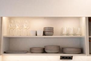 a shelf with glasses and plates in a kitchen at Casa Cuca O Grove in O Grove