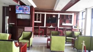 a waiting room with green chairs and a television at FT Hotel in Addis Ababa