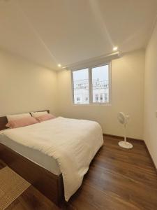 a bedroom with a large bed and a window at KP Home in Xuân Trach