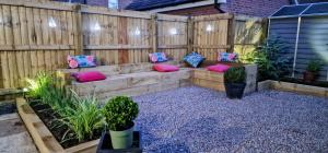 a wooden bench in a garden with pillows at Kings Sconce in South Muskham