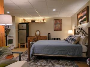 a bedroom with a bed and a table and a refrigerator at Private White Mountains Guest Suite - Welcome! in Littleton