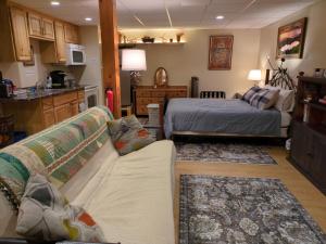 a living room with a couch and a bed at Private White Mountains Guest Suite - Welcome! in Littleton