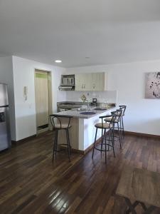 a kitchen with a counter and stools in a room at Lindo apto cerca a todo! in Sabaneta