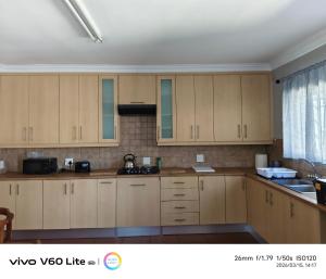 a kitchen with wooden cabinets and a window at Firehouse self-catering unit 6 in Wellington