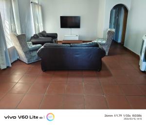 a living room with a couch and chairs and a television at Firehouse self-catering unit 6 in Wellington