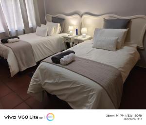 two beds in a hotel room with towels on them at Firehouse self-catering unit 6 in Wellington +3 photos
