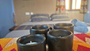 a group of candles sitting on a table with a bed at Emo Guesthouse in Kpandu