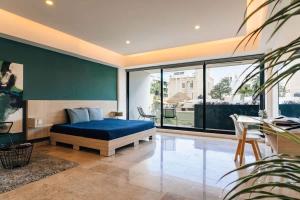 a bedroom with a blue bed and a large window at Beautiful apartment Top location! in Playa del Carmen