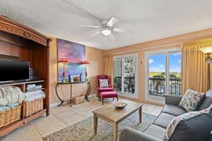 a living room with a couch and a tv at A-110, Pinnacle Port in Panama City Beach