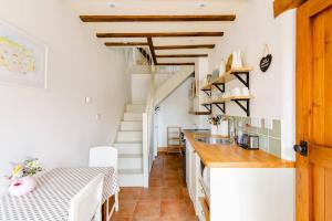 a kitchen with white walls and a wooden ceiling at Norfolk Broads Bolthole in Stokesby