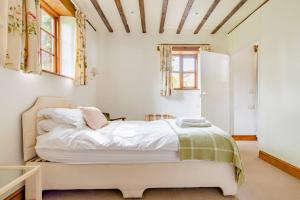 a bedroom with a large bed with white sheets at Norfolk Broads Bolthole in Stokesby +33 photos