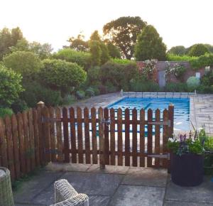 a wooden fence in front of a swimming pool at Norfolk Broads Bolthole in Stokesby