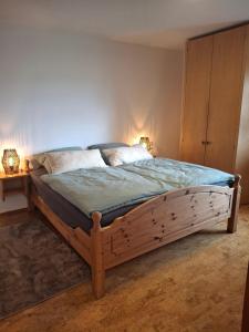 a bedroom with a wooden bed with two lamps on it at Ferienwohnung Theresia in Laufen