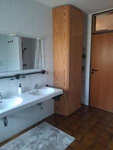 a bathroom with two sinks and a mirror and a door at Ferienwohnung Theresia in Laufen +8 photos
