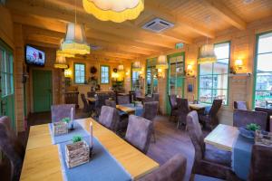 a restaurant with wooden walls and tables and chairs at Grădina Lu' Ion -A Home Away From Home & Chic Restaurant Traditional in Vişeu de Sus