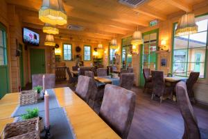 a restaurant with wooden floors and tables and chairs at Grădina Lu' Ion -A Home Away From Home & Chic Restaurant Traditional in Vişeu de Sus