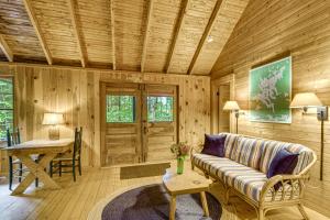 a living room with a couch and a table at Rustic Cabin w/ Squam Lake Access & Fireplace! in Holderness