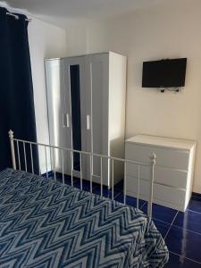 a bedroom with a bed and a tv on a wall at MAGA House in Pontecagnano