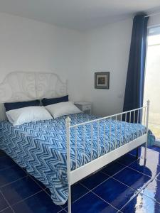 a bed with a blue and white comforter in a room at MAGA House in Pontecagnano