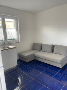 a living room with a couch and a blue tile floor at MAGA House in Pontecagnano