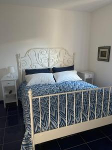 a bedroom with a bed with a blue and white comforter at MAGA House in Pontecagnano