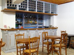 a kitchen with a bar with wooden tables and chairs at Ilion Hotel in Nafpaktos