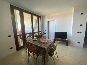 a dining room with a table and chairs and a television at Appartamento Gardenia in Saronno