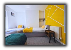 a room with two beds and a table in it at Pitchside Quarters Near Anfield sleeps 7 in Liverpool