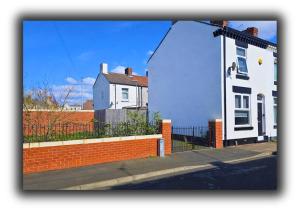 a white house on the side of a street at Pitchside Quarters Near Anfield sleeps 7 in Liverpool