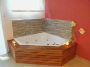 a bath tub in a bathroom with a red wall at Epuyen in Chascomús