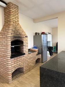 a brick oven in a kitchen with a refrigerator at Chácara Vittorino in Artur Nogueira
