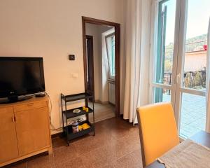 a living room with a flat screen tv and a window at Terrazza Le Grazie in Le Grazie