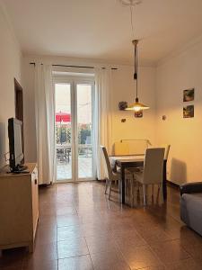 a dining room with a table and chairs and a television at Terrazza Le Grazie in Le Grazie