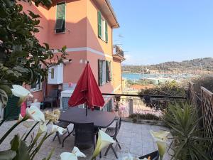 a patio with a table and chairs and a building at Terrazza Le Grazie in Le Grazie