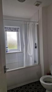 a bathroom with a shower with a toilet and a window at Amani Sanctuary 2 Bedroom House in Sherburn Hill