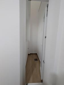 a hallway with white walls and a wooden floor at Apartamento Calle Bolsa in Sanlúcar de Barrameda