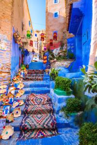 a narrow alley with blue walls and blue stairs at Morocco PALACE in Chefchaouen