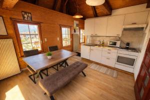 a kitchen with a wooden table and a dining room at JSM è in Därligen