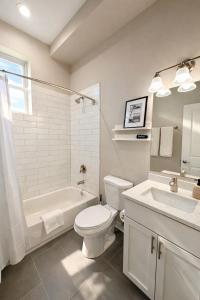 a bathroom with a toilet and a tub and a sink at Flexhome West Town - Spacious 2BR Duplex - Sleeps 8 in Chicago +16 photos