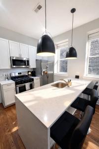 a kitchen with a white counter and black appliances at Flexhome West Town - Spacious 2BR Duplex - Sleeps 8 in Chicago