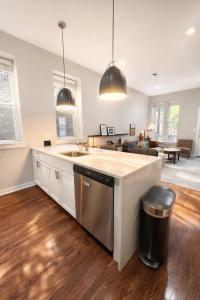 a kitchen with a sink and a living room at Flexhome West Town - Spacious 2BR Duplex - Sleeps 8 in Chicago