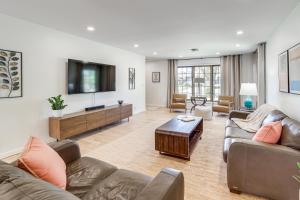 a living room with couches and a flat screen tv at Midtown Tulsa Gem w/ MCM Decor: Private Deck, Yard in Tulsa