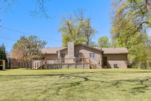 a large house with a fence in front of it at Midtown Tulsa Gem w/ MCM Decor: Private Deck, Yard in Tulsa