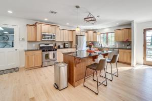 a kitchen with wooden cabinets and stainless steel appliances at Midtown Tulsa Gem w/ MCM Decor: Private Deck, Yard in Tulsa