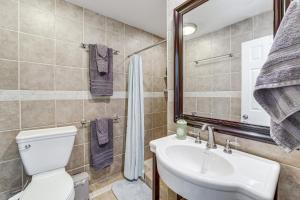 a bathroom with a toilet and a sink and a mirror at Midtown Tulsa Gem w/ MCM Decor: Private Deck, Yard in Tulsa +18 photos