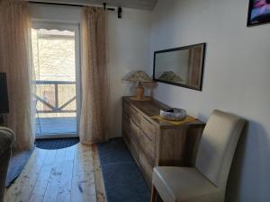 a bedroom with a dresser and a chair and a mirror at Landhotel Eisdorf in Eisdorf