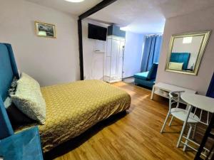 a bedroom with a bed and a table and a mirror at Suite Azul 3 personas comoda y equipada in Mexico City