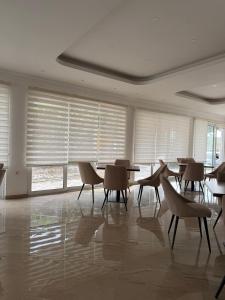 a dining room with chairs and tables and windows at Long Beach Truma in Ulcinj