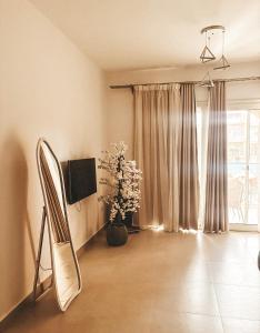 a living room with a television and a vase of flowers at Green studio in Dahab in Dahab