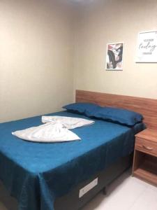a bedroom with a blue bed with a blue bedspread at Flat Guaramiranga - Apto 202 in Guaramiranga